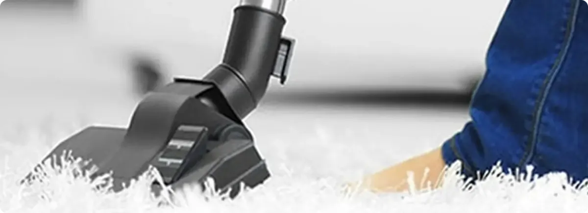 Close-up of a professional vacuuming a white carpet in Curtis Bay.